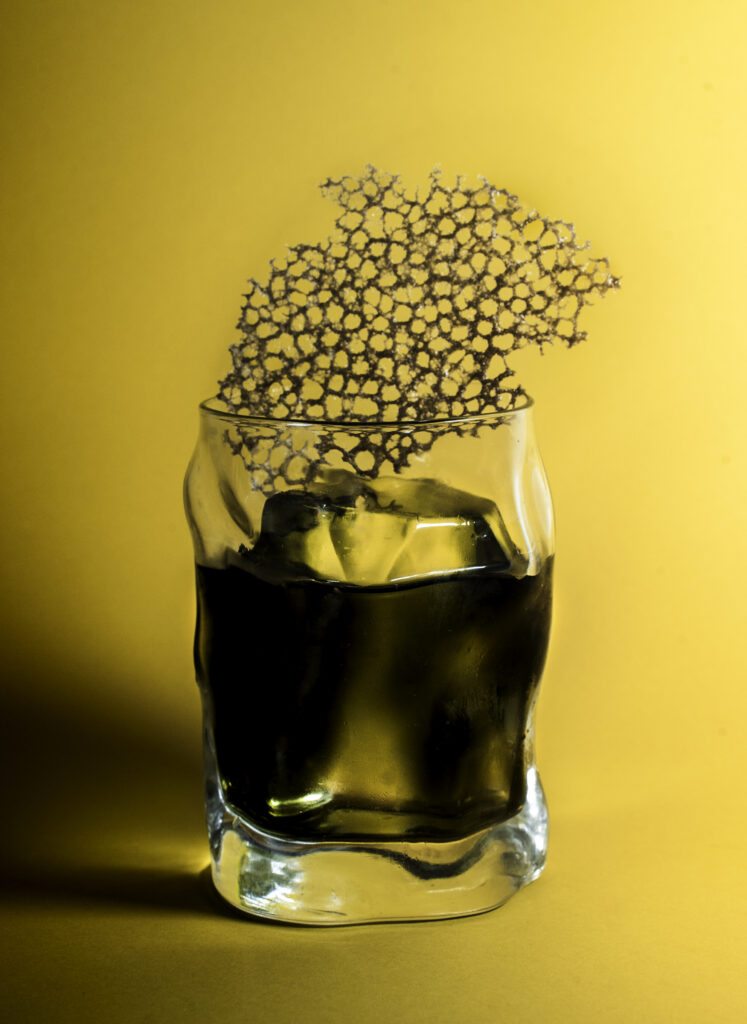 cocktail noir à l'encre de seiche sur fond jaune